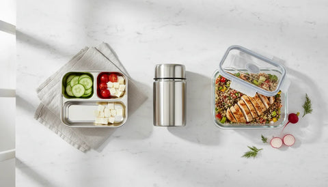 Madkasse i rustfrit stål, termomadkasse og glasbeholder set ovenfra på lyst køkkenbord - de tre typer kemifri madkasser fra Yummii Yummii